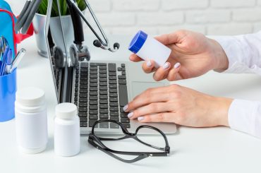 Female doctor is typing in laptop computer