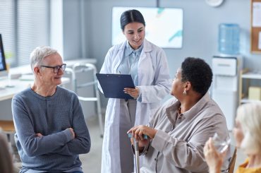 Portrait of smiling female therapist talking to seniors in mental health support group